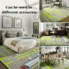 A large outdoor area rug featuring a tropical botanical design with bright green and gray tones.