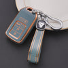 A teal TPU protective key case with a silver clip and leather strap is shown resting on a white plate.
