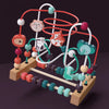 A wooden bead maze toy featuring red and white strings, beads, and small animal figures for toddlers.