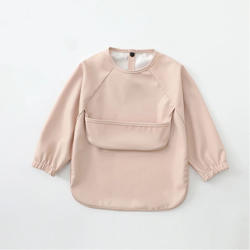 A light pink waterproof long-sleeve smock for toddlers with a pocket on the chest.