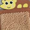 A close-up of a brown felt board with a yellow animal face attached, showing a textured sensory mat.