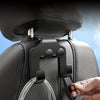 A black phone holder hook is being attached to a car back seat fabric using a clear plastic clip.