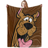 Eine Person hält eine Flanell-Überwurfdecke mit dem Gesicht des Hundes Scooby-Doo.