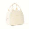 A cream-colored embroidered corduroy insulated lunch bag with light beige fabric handles.