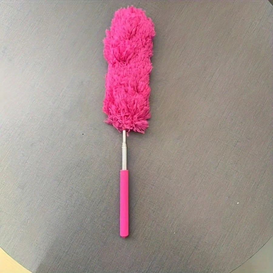 A bright pink flexible microfiber duster with a handle is shown against a gray background.