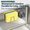A yellow sponge holder and a black metal scrubber are shown on a stainless steel kitchen sink.