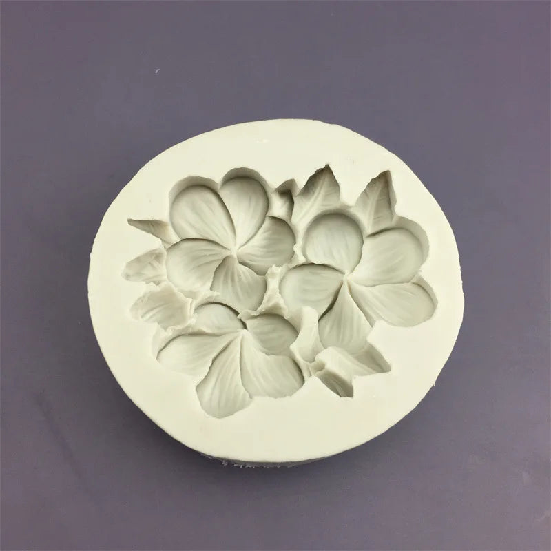 A white silicone mold shaped like three overlapping flowers for baking and crafting.