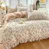 A floral ruffle cotton duvet cover set featuring a light beige background with small blue and green floral patterns.