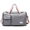 A gray travel duffel bag with pink straps and a separate shoe compartment pocket.
