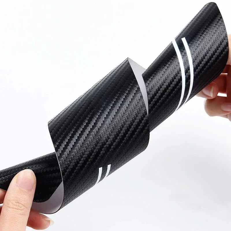 Black carbon fiber door sill protectors for Dodge RAM trucks shown being held.