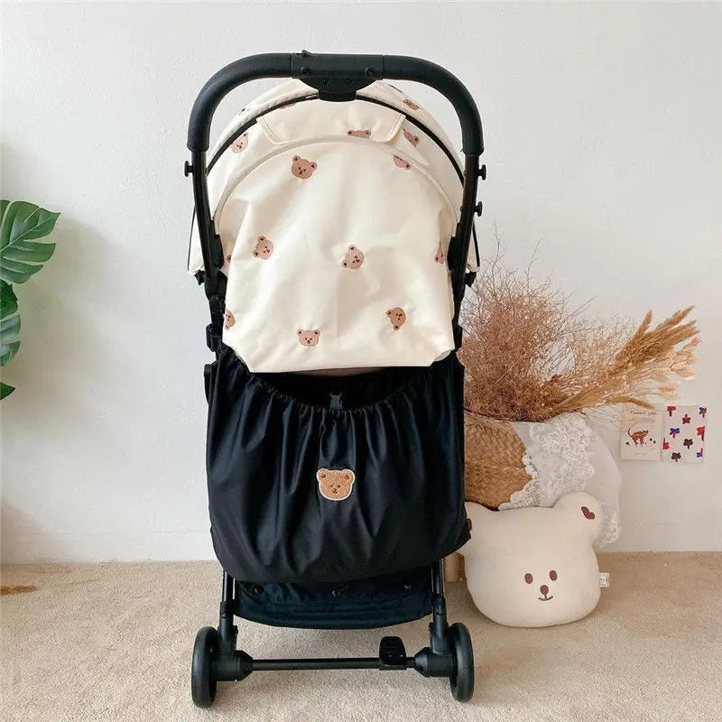 A black stroller organizer backpack featuring a bear theme with small pink ears and a large capacity.