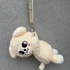 A light yellow fluffy plush toy of a cute animal character hanging by a strap.