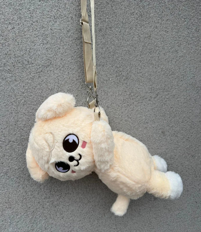 A light yellow fluffy plush toy of a cute animal character hanging by a strap.