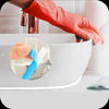 A hand in a red glove is applying blue self-adhesive tile gap tape to a white ceramic bowl.