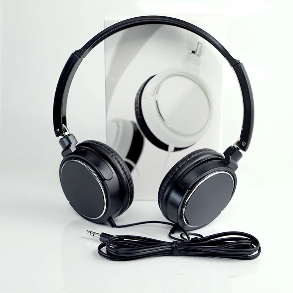 Black foldable stereo wired headphones with a flexible headband and earcups resting on a white surface.