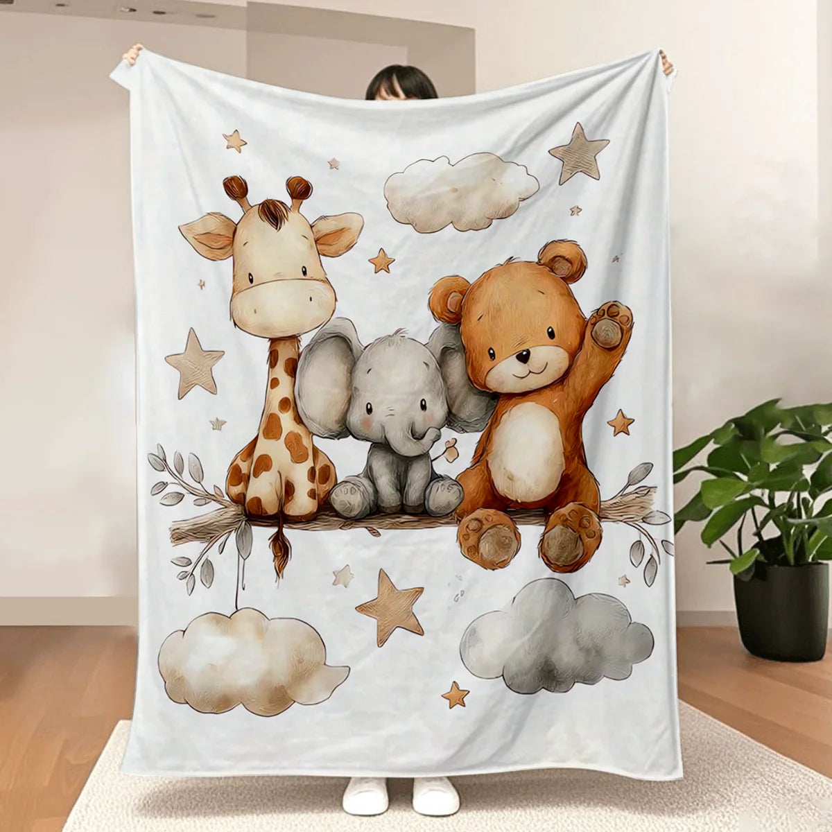A white blanket featuring watercolor illustrations of a giraffe, an elephant, and a teddy bear.