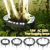 A set of tree-hugging LED garden lights with ground spikes illuminating a plant in a natural setting.