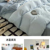 A set of four ultra-soft washed cotton duvet covers in a light blue or pale gray color displayed on a bed.