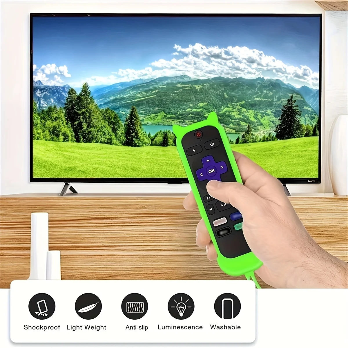 A hand holds a bright green silicone remote control cover for a TV, displayed in front of a large monitor.