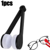 A black microfiber cleaning tool for glasses is shown next to a pair of eyeglasses.