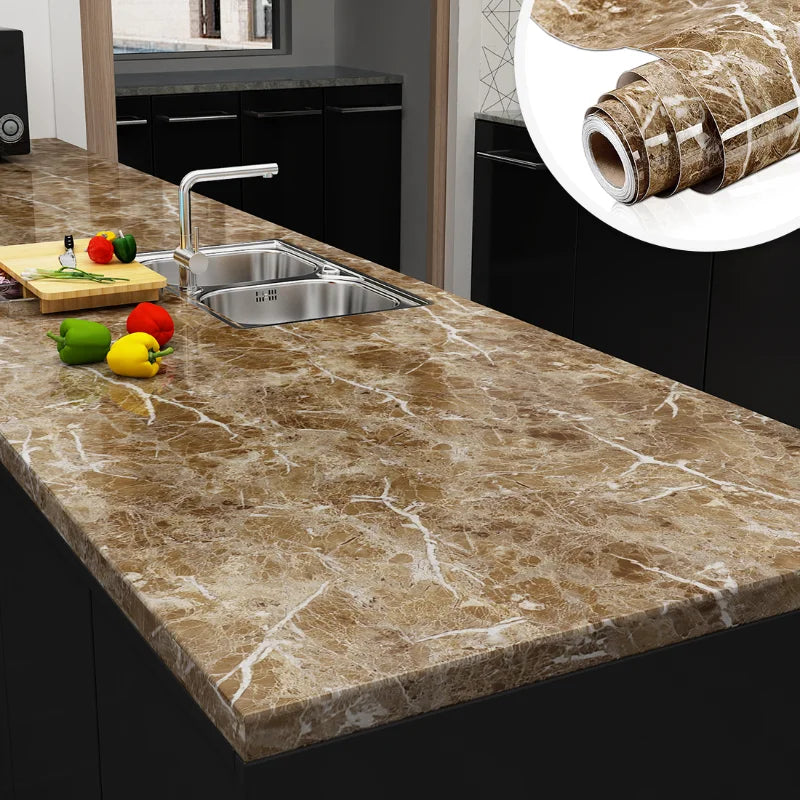 A kitchen countertop made of marble contact paper with a faucet, fruit, and rolled-up decorative paper visible.