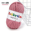 A skein of pink soft T-shirt yarn used for crochet and knitting is shown next to a wire basket.