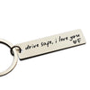 A personalized stainless steel keychain tag engraved with the message drive safe i love you and a heart symbol.