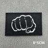 Black tactical patch featuring a white clenched fist design with hook and loop backing