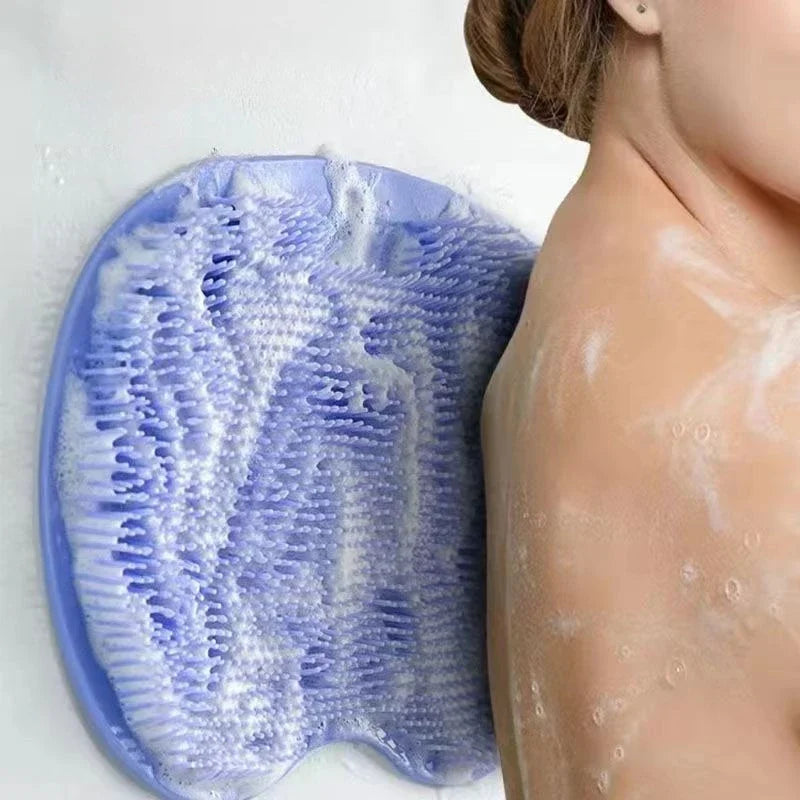 A close-up of a blue silicone shower mat with exfoliating bristles is shown next to a person's skin.