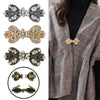 A collection of vintage bowknot rhinestone clothing clips in silver, gold, and bronze tones displayed against a plaid fabric.