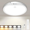 A white rechargeable motion sensor ceiling light fixture is mounted on a ceiling, with several recessed lights below it.