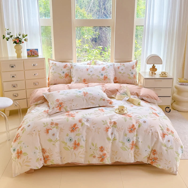 A light pink and white printed duvet cover set with matching pillowcases displayed on a bed in a bright room.