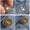 A set of bronze buttons featuring the 'SHENG JEANS' logo attached to denim fabric.
