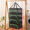 A folding wooden rack displays a cylindrical black mesh drying net with green accents.