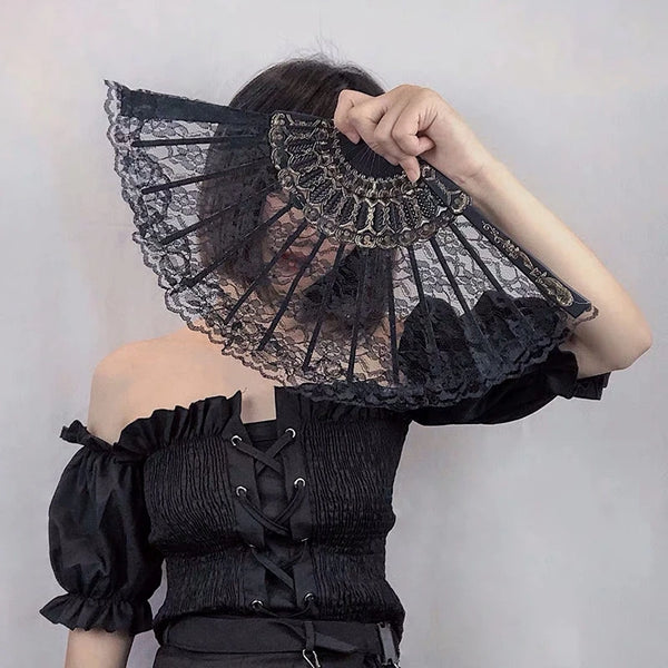 A black vintage lace folding hand fan with a decorative handle is held by a person.