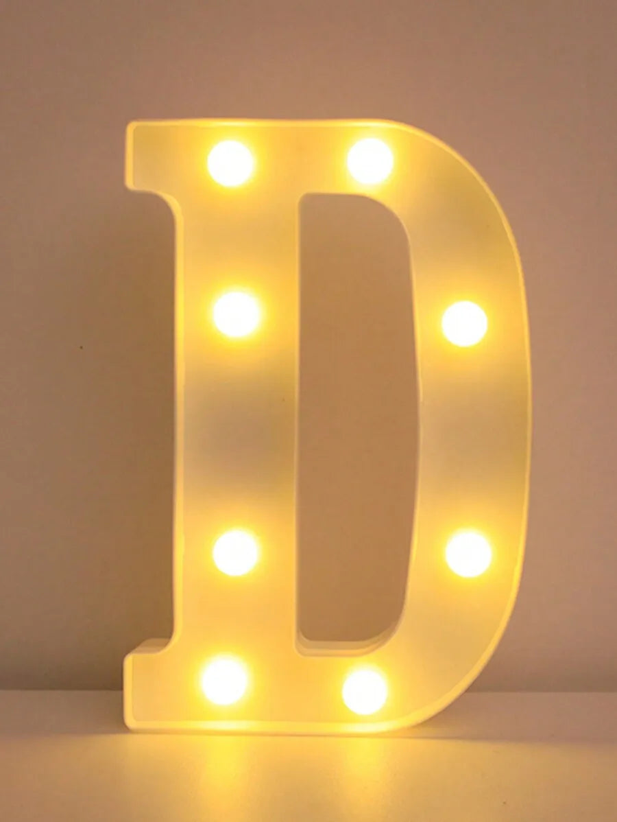 A glowing yellow LED letter D night light with illuminated dots, used for home and party decor.