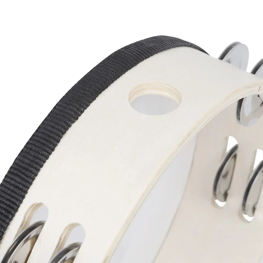 A close-up view of a white wooden tambourine with silver jingle bells and a black strap.