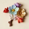 A cluster of colorful lotus flowers in various shades of pink, blue, purple, and gold on a branch.