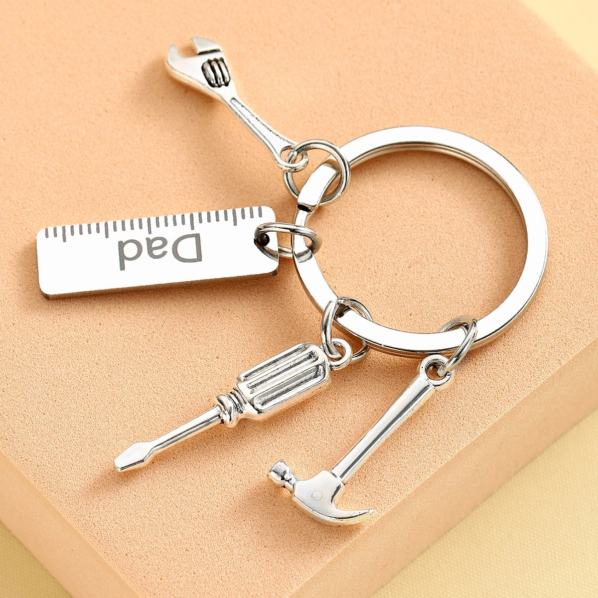 Silver compact multi-tool keychain featuring a Dad-themed tag and various small tools.