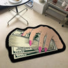 A hand is holding a fan of US dollar bills on a black non-slip rug.