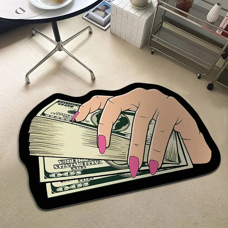 A hand is holding a fan of US dollar bills on a black non-slip rug.