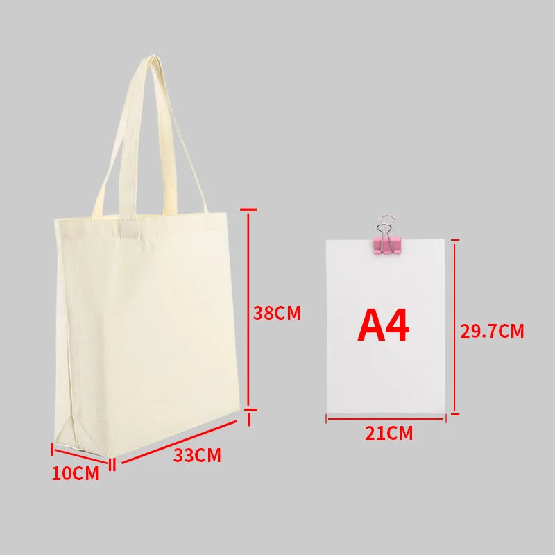 A beige canvas shopping tote bag shown with its dimensions and an A4 sized paper for scale.