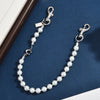 Silver pearl necklace with a letter C charm detail displayed on a dark blue velvet surface.