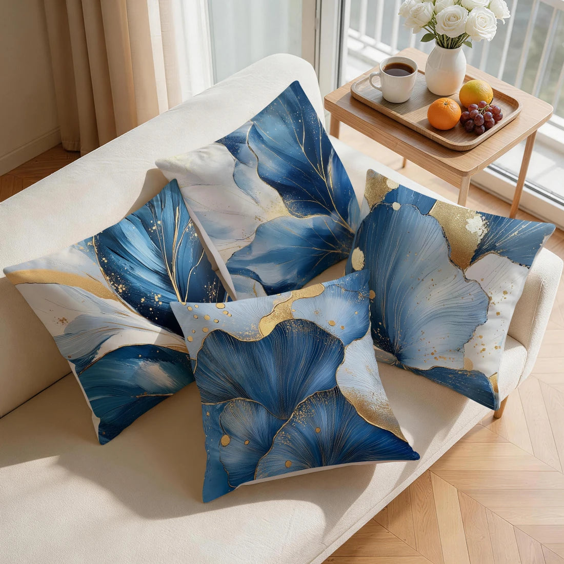 Blue and gold abstract leaf print cushion covers displayed on a light sofa.