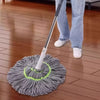 A person is using a hands-free self-wringing spin mop with a rotating head on a wooden floor.