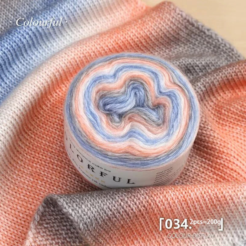 A ball of colorful gradient yarn is displayed on a peach-colored knitted fabric.