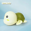 A white and green wind-up turtle bath toy is shown against a light blue background.