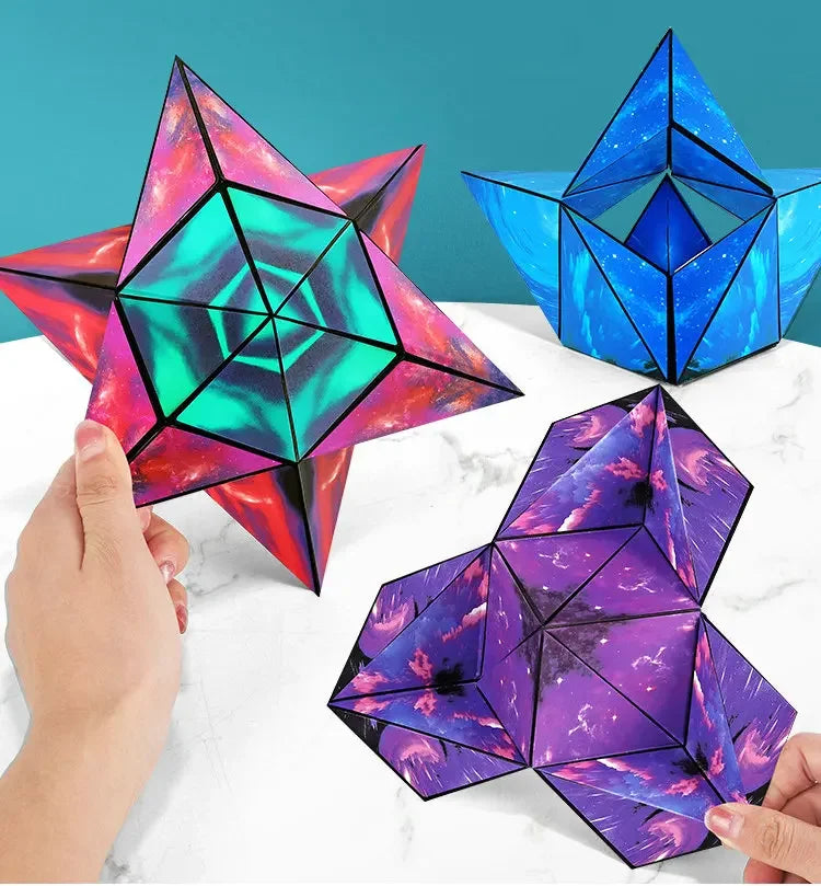 Three magnetic fidget cubes in pink, blue, and purple form geometric 3D puzzles on a white surface.