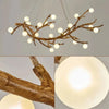 A chandelier featuring a branch-like light fixture with multiple spherical glass bulbs.