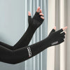 Black sports arm sleeves worn on an arm against a light gray curtain backdrop.